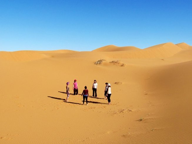Group of women doing 5 Elements dance meditation in desert