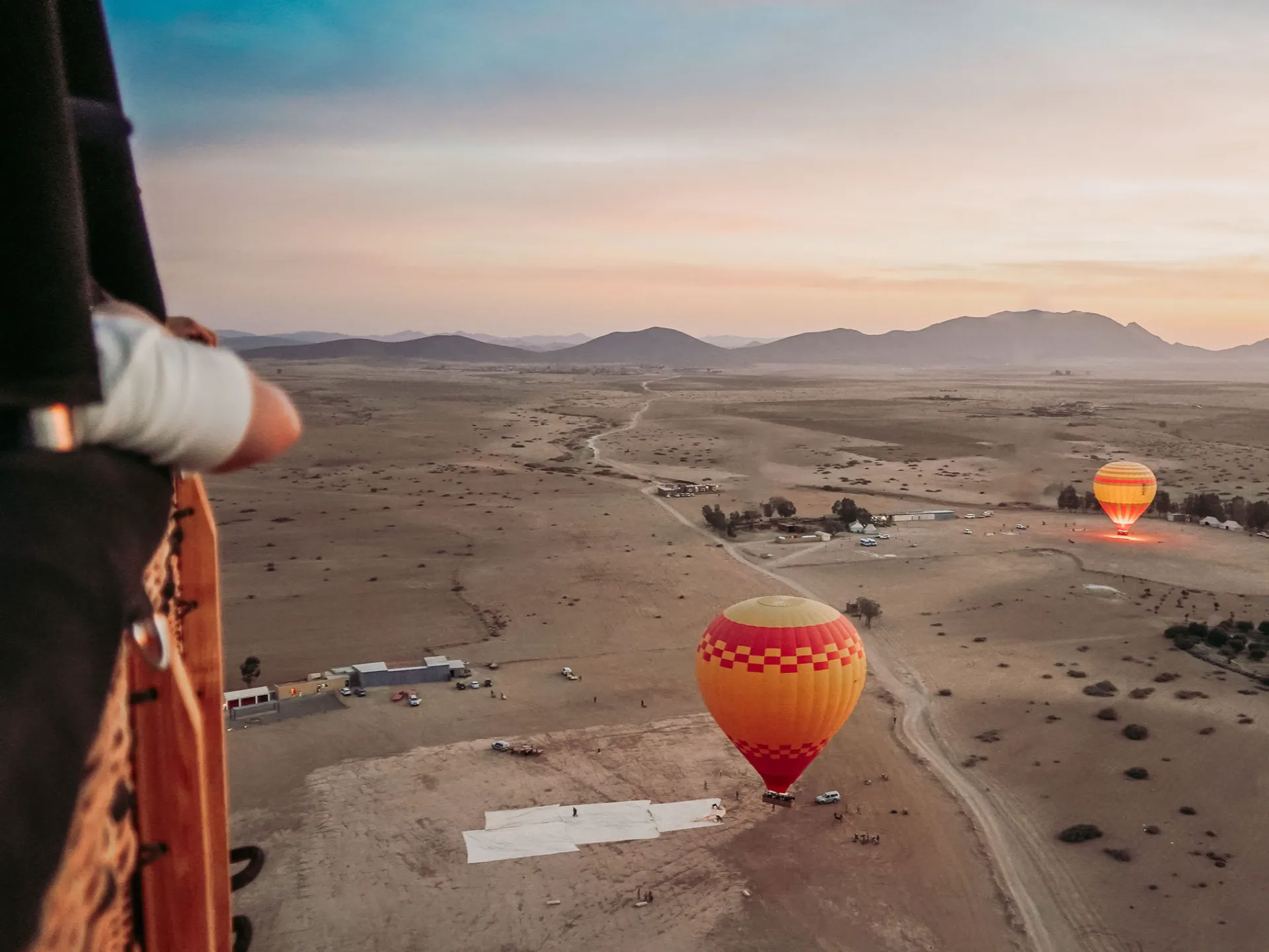 Hot air balloon flying over Marrakech desert at sunrise