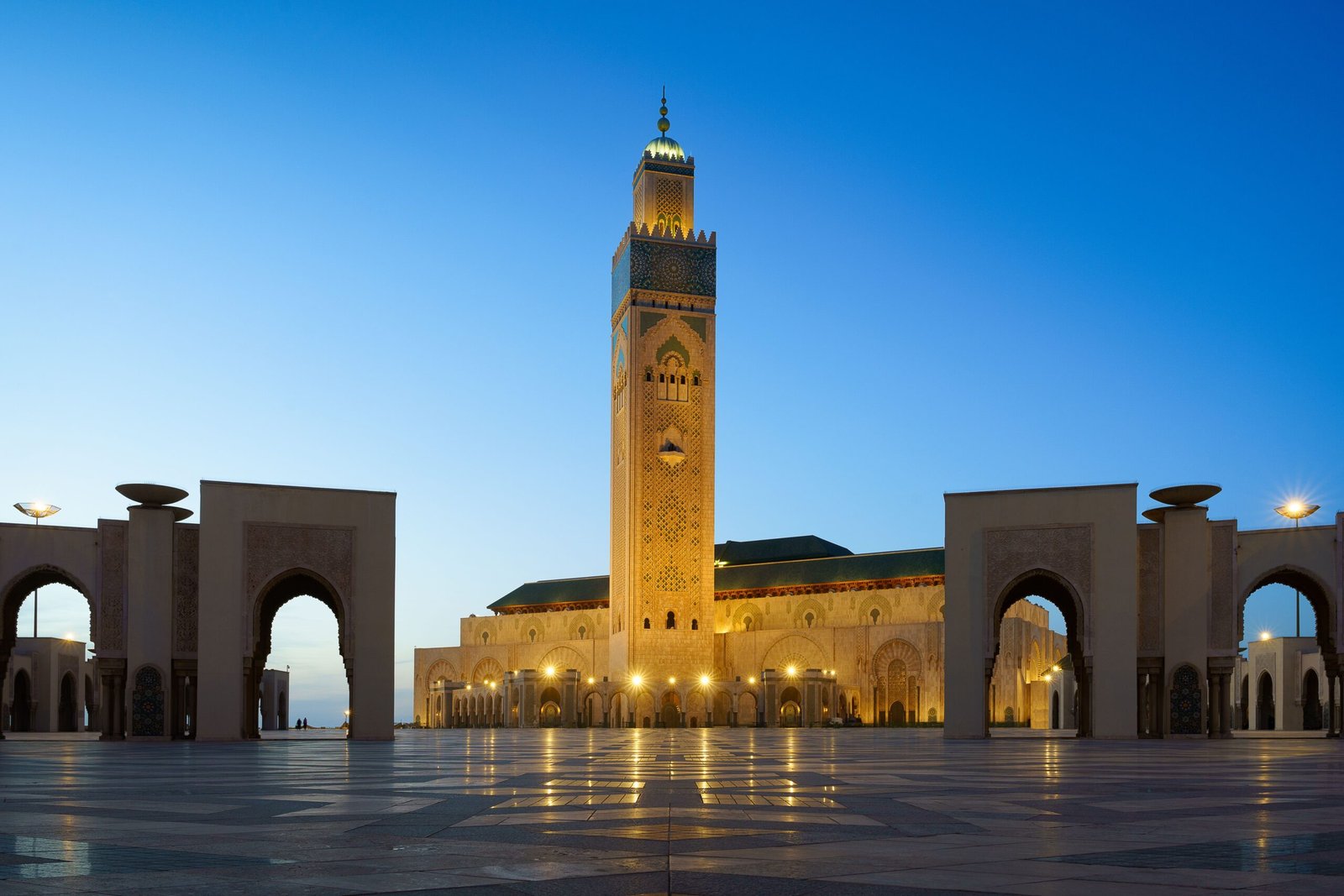 Hassan II Mosque illuminated at night with reflection
