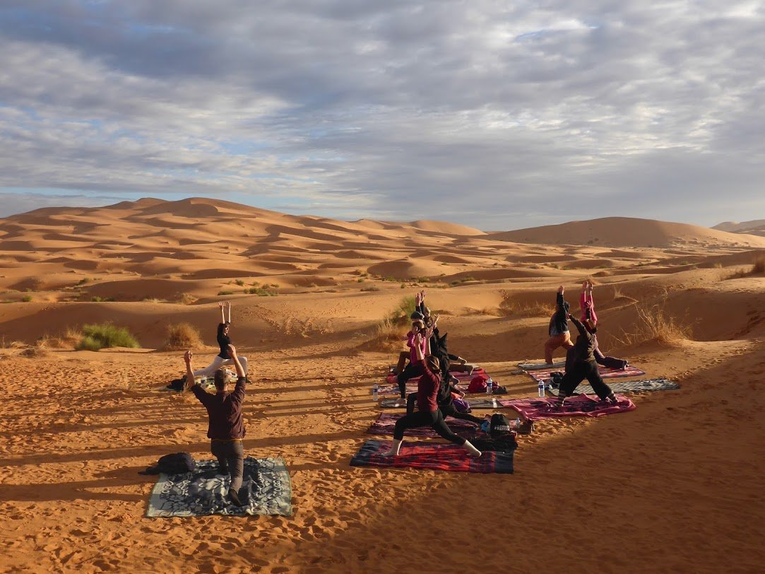 Yoga practice shadow on Sahara desert sand
